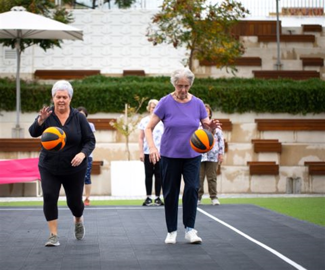 two_women_bouncing_netball_while_playing_walking_netball.jpg