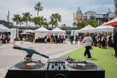 Records playing on decks with crowd in background