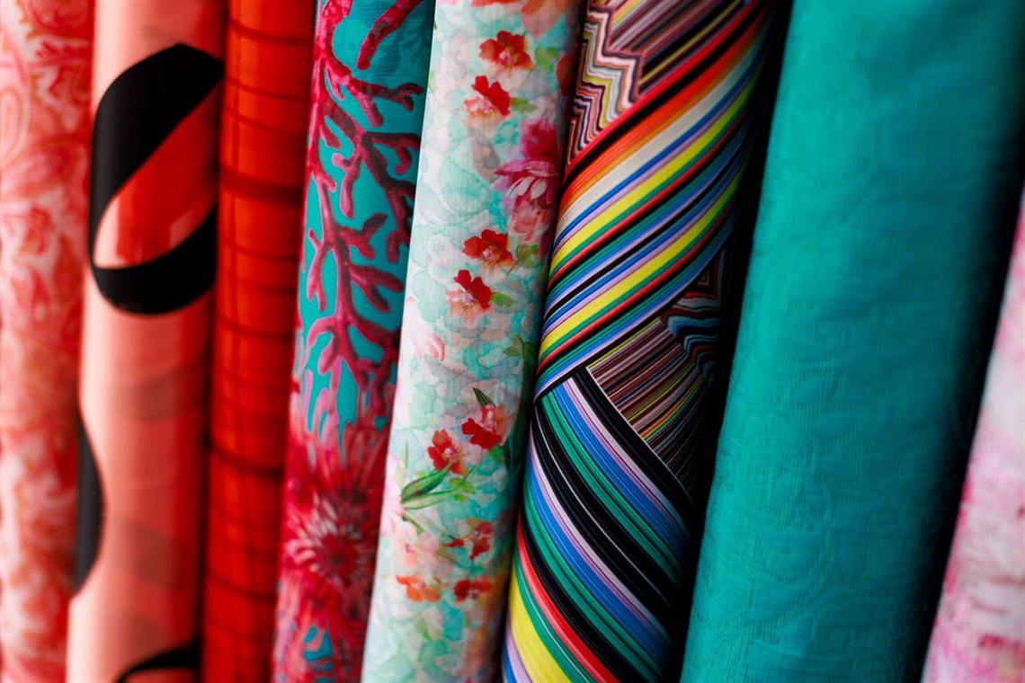 Rolls of colourful printed fabric.