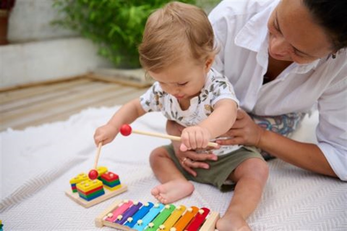 Mother_holding_baby_up_to_musical_instrument